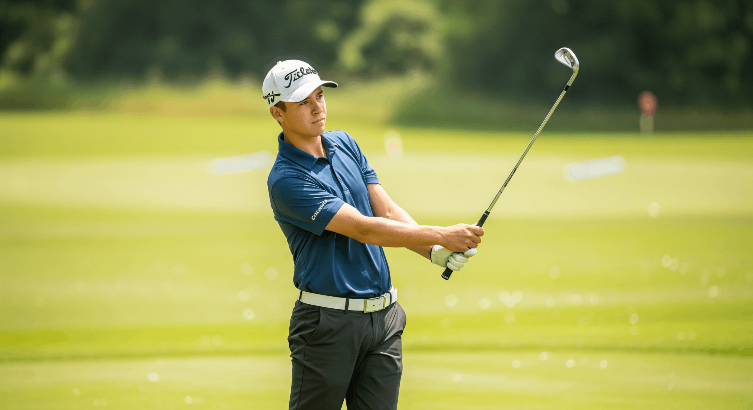 Golfer completing an iron shot follow-through on a practice fairway